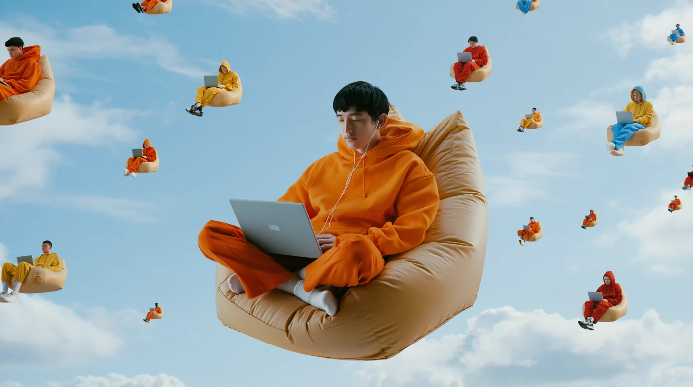 Creator in an orange hoodie floating above the clouds