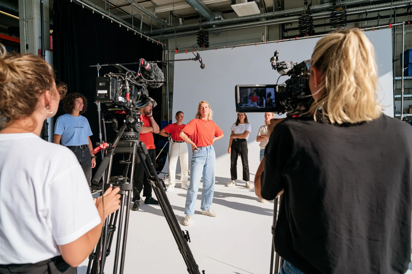 Film crew recording a presenter in a production studio